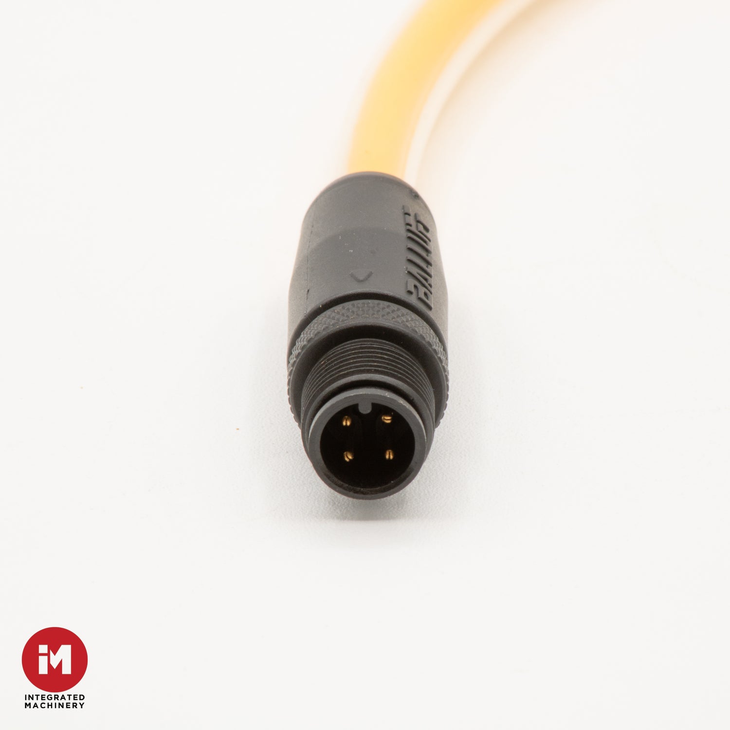 Close-up of a black connector with a yellow cable on a white background, featuring the Integrated Machinery logo.